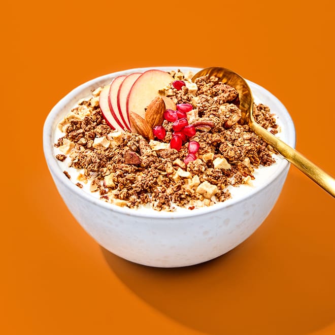 Granola Einsteiger Paket mit Apfelscheiben, Mandeln und Granatapfelkernen in einer weißen Schüssel